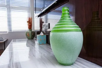 a green and white vase sitting on a table at Lovely Studio w Full Kitchen in Heart of San Diego in San Diego