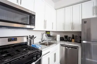a kitchen with white cabinets and a stainless steel appliances at Luxurious Furnished Studio w Full Kitchen in SD in San Diego