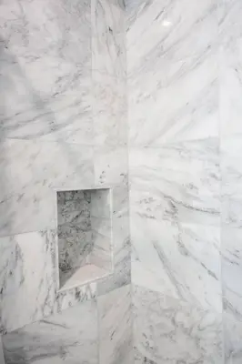 a white marble bathroom with a niche in the wall at Luxurious Furnished Studio w Full Kitchen in SD in San Diego