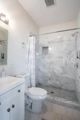 a white bathroom with a toilet and a shower at 2 Bedroom, 2 Bathroom Detached Apt Max 7 Sleepers in San Diego
