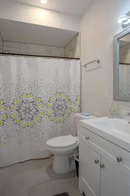 a bathroom with a toilet and a sink and a shower curtain at One Bedroom Apartment with San Diego Downtown View in San Diego