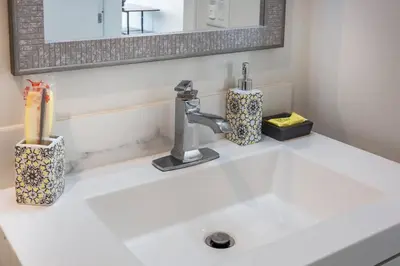 a bathroom sink with a faucet and a mirror at One Bedroom Apartment with San Diego Downtown View in San Diego