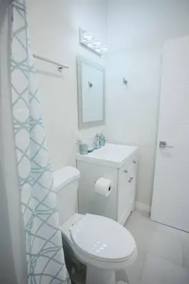 a white bathroom with a toilet and a sink at Spacious 500 sqft Studio with Balboa Park View in San Diego