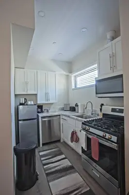 a kitchen with stainless steel appliances and white cabinets at Spacious 500 sqft Studio with Balboa Park View in San Diego