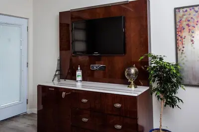 a living room with a dresser with a television on it at 1 Bedroom Apartment with Luxurious Design in SD in San Diego