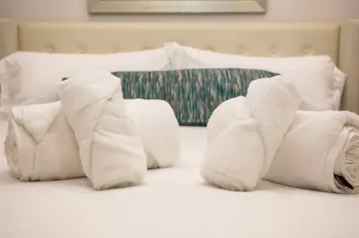 a pile of towels sitting on top of a bed at The Most Beautiful Bay View from 1 Bedroom Apt in San Diego