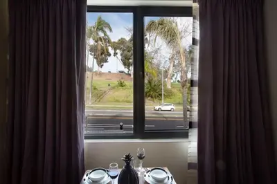 a window with a view of a white car on a street at Luxurious One Bedroom Suite with Balboa Park View in San Diego