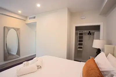 a white bedroom with a bed with towels on it at Luxurious One Bedroom Suite with Balboa Park View in San Diego