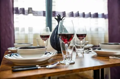 a table with glasses of wine and plates on it at Luxurious One Bedroom Suite with Balboa Park View in San Diego