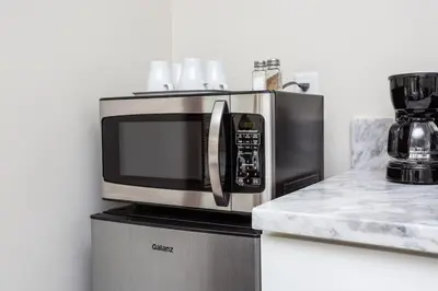 a microwave oven sitting on top of a refrigerator at Next to San Diego Downtown - Cali King Size Studio in San Diego