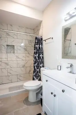 a white bathroom with a toilet and a sink at Next to San Diego Downtown - Cali King Size Studio in San Diego