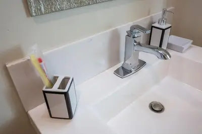 a bathroom sink with a toothbrush holder and a faucet at Next to San Diego Downtown - Cali King Size Studio in San Diego