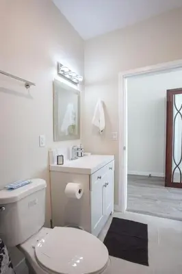 a white bathroom with a toilet and a shower at Next to San Diego Downtown - Cali King Size Studio in San Diego
