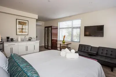 a bedroom with a large white bed and a kitchen at Next to San Diego Downtown - Cali King Size Studio in San Diego