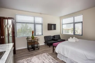 a bedroom with a bed and a couch and a chair at Next to San Diego Downtown - Cali King Size Studio in San Diego