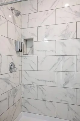 a bathroom with a shower with white marble tiles at Studio with Beautiful View next to Downtown in San Diego