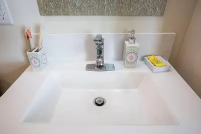 a white bathroom sink with toothbrushes and toothpaste at Modern, Luxurious and Prime location All in One in San Diego