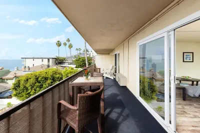 a balcony with a table and chairs and a view of the ocean at Pacific Edge Hotel in Laguna Beach