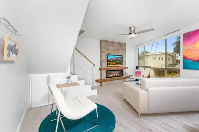 a living room with a white couch and a fireplace at Highly rated Best Beach! AC Luxury KING Beds! in San Diego
