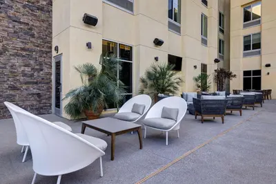 a row of white chairs and tables in front of a building at Hilton Garden Inn Temecula in Temecula