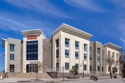 a large white building with a red sign on it at Hilton Garden Inn Temecula in Temecula