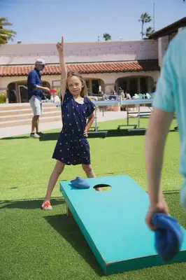 a little girl is playing with a kite in a field at Kona Kai Resort & Spa, a Noble House Resort in San Diego