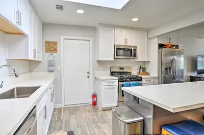 a kitchen with white cabinets and stainless steel appliances at San Marcos Home with Patio and Grill - Walk to Lake! in San Marcos