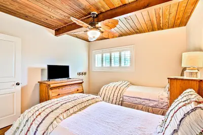 two beds in a bedroom with a ceiling fan at California Getaway in San Clemente