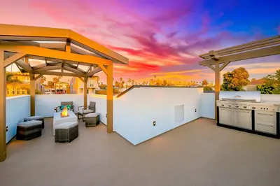 an outdoor kitchen with a sunset in the background at New Tremont Modern Beach in Oceanside