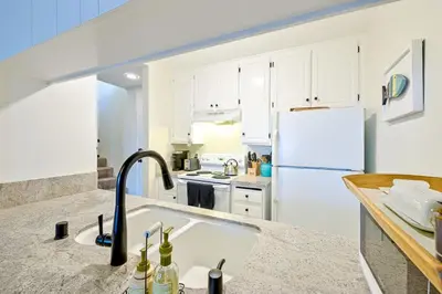 a kitchen with a sink and a white refrigerator at Pier View Retreat in Oceanside