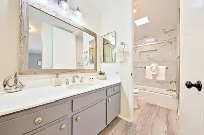 a white bathroom with a sink and a shower at Pier View Retreat in Oceanside