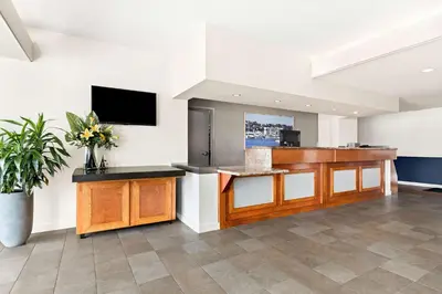 a kitchen with a counter and a tv on a wall at Best Western Yacht Harbor Hotel in San Diego