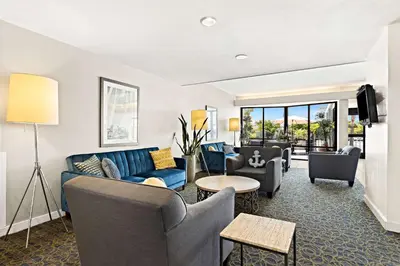 a living room with a blue couch and chairs at Best Western Yacht Harbor Hotel in San Diego
