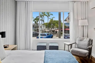 a hotel room with a bed and a chair and a window at Sea Harbor Hotel - San Diego in San Diego