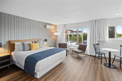 a hotel room with a bed and a table and chairs at Sea Harbor Hotel - San Diego in San Diego