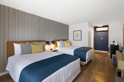 a hotel room with two beds and a television at Sea Harbor Hotel - San Diego in San Diego