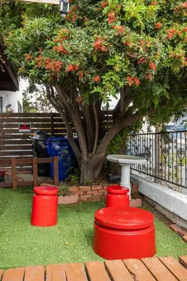 three red barrels sitting on the grass in front of a tree at COZY Studio in Downtown San Diego in San Diego