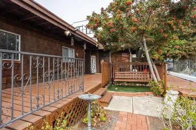 a porch of a house with a bench and a tree at COZY Studio in Downtown San Diego in San Diego