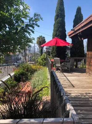 a wooden deck with a red umbrella and a bench at Special Studio in Center of San Diego in San Diego
