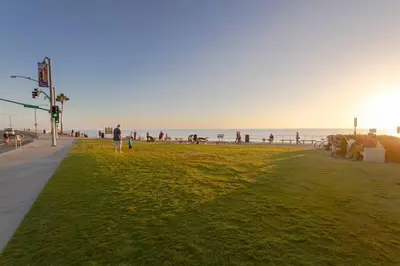 a person walking on the beach with the ocean in the background at Great Group Retreat! Hacienda Decor, Spacious Floor Plan, Private Backyard in Carlsbad