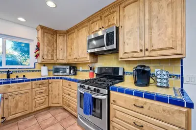 a kitchen with wooden cabinets and stainless steel appliances at Great Group Retreat! Hacienda Decor, Spacious Floor Plan, Private Backyard in Carlsbad