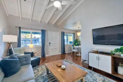 a living room with a couch and a tv at 90 Walk Score - Steps to Beach & Dining - Reserved Parking in Carlsbad