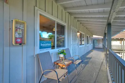 a porch with two chairs and a table on it at 90 Walk Score - Steps to Beach & Dining - Reserved Parking in Carlsbad