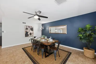 a dining room with a table and a ceiling fan at 4 BR Home with Game Room! Family Friendly! Centrally Located! in San Diego