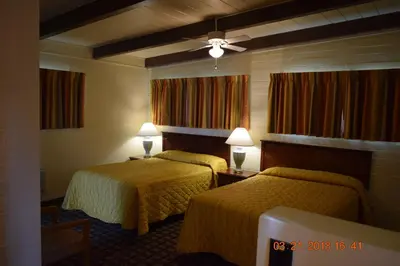 a hotel room with two beds and two lamps at Stanlunds Inn and Suites in Borrego Springs
