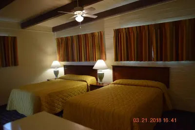 a hotel room with two beds and a ceiling fan at Stanlunds Inn and Suites in Borrego Springs