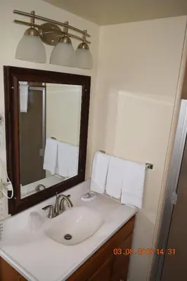 a bathroom with a sink and a mirror and towels at Stanlunds Inn and Suites in Borrego Springs