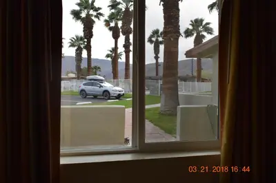 a window with a view of a car in a parking lot at Stanlunds Inn and Suites in Borrego Springs
