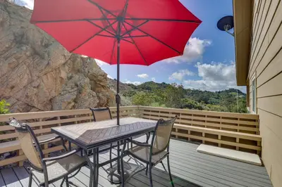 a table with a red umbrella on a deck at Hot Tub and Balcony Rainbow Retreat Near Wineries! in Fallbrook