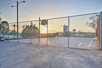 an empty basketball court behind a fence with a basketball hoop at Quaint La Mesa Home with Beautiful Sunsets! in La Mesa